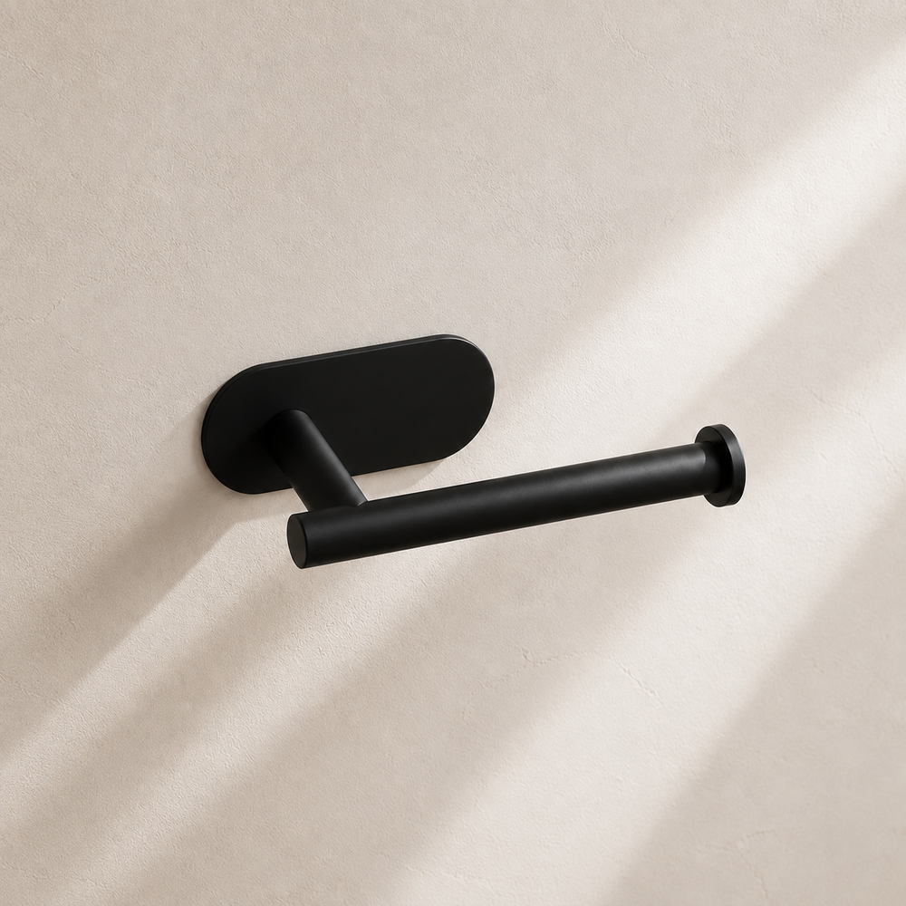 Matte black self-adhesive toilet paper holder in warm neutral studio setting