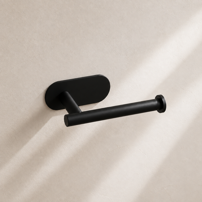 Matte black self-adhesive toilet paper holder in warm neutral studio setting